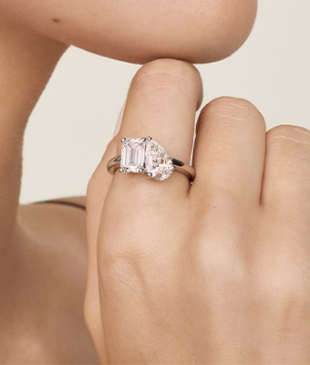 Elegant two-stone diamond ring on a hand, with “Special Buys” and “Shop Now” text